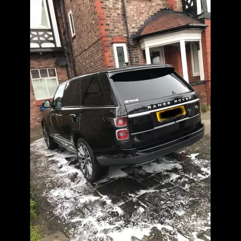 Dr. Autocare technician performing a mobile car valet on a Range Rover at a residential driveway in Stockport — fully self-contained service